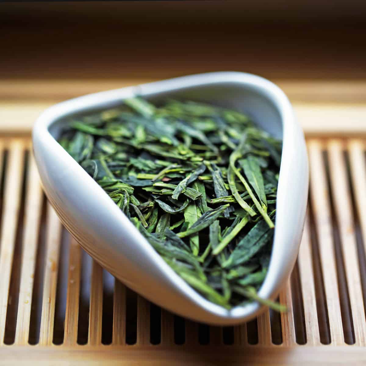 dragon well green tea in a white presentation vessel