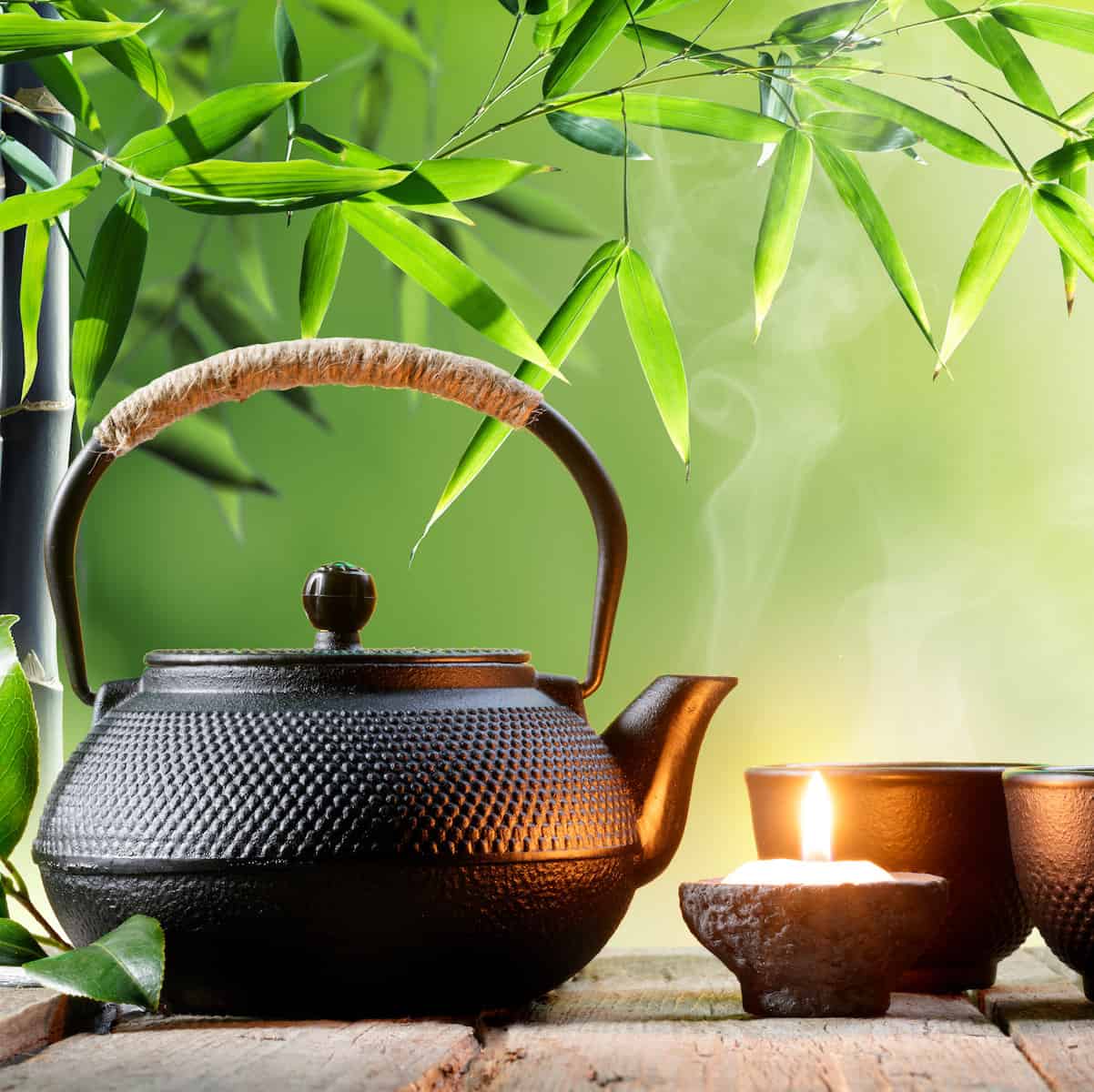 learn about tea Black iron teapot with green tea leaves