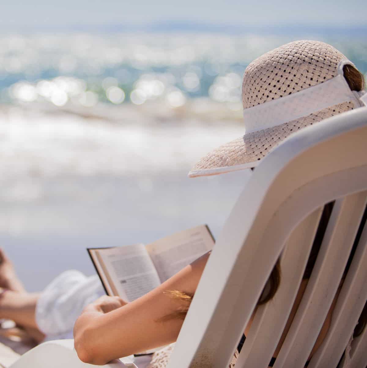 woman in lounge chair reading book beach reads books about tea